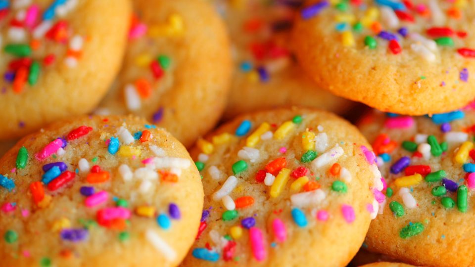 Round biscuits covered in rainbow coloured sprinkles