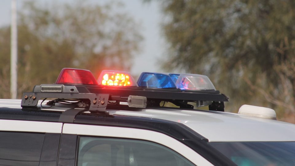 Red and blue lights glowing on the roof light bar of a police car