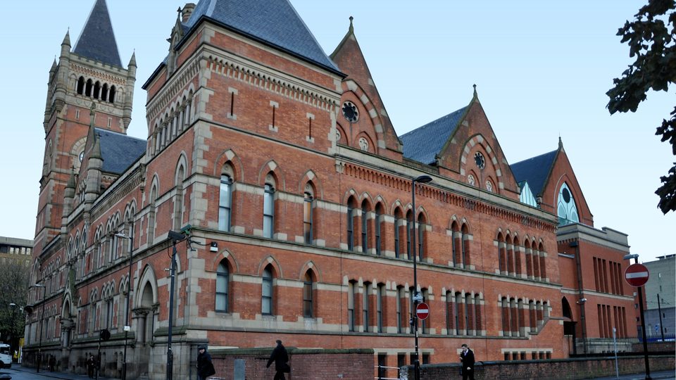 The red brick Gothic Minshull Street Crown Court in Manchester under a clear sky