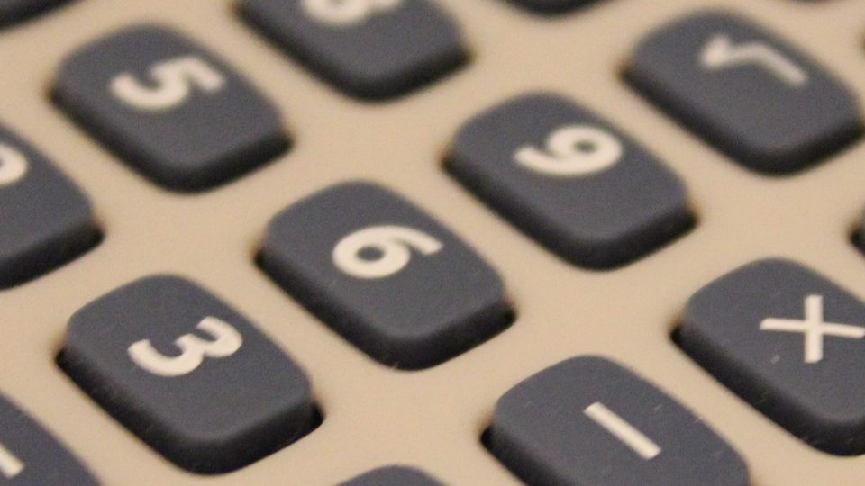 Close view of the slate blue number keys of a calculator, angled and softly focused