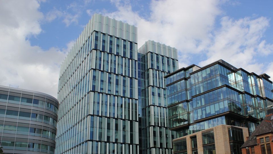The glass office towers of Hardman Square in Spinningfields, Manchester, including 3 Hardman Street, the GMC's Manchester office, under a bright sky